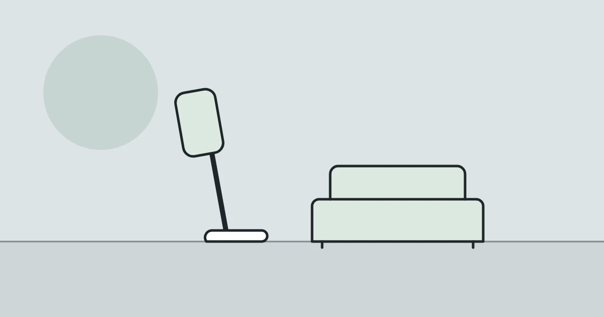 Illustration of a cordless stick vacuum and a sofa